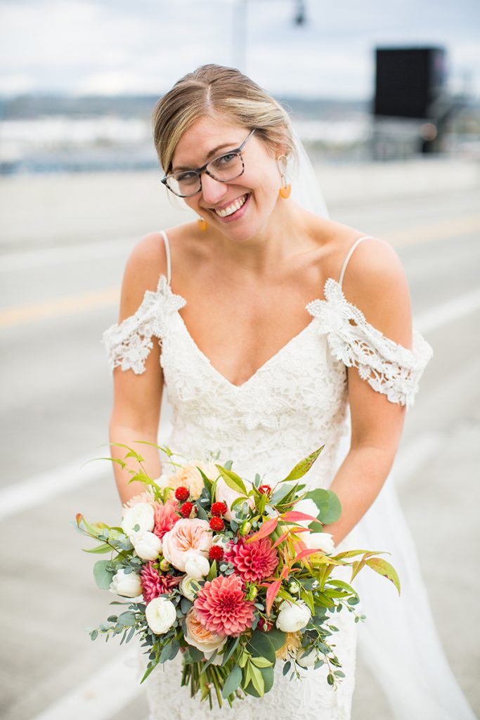 Bride with bouquet of dahlias, garden roses, tulips, ranunculus, and greens by Jen's Blossoms